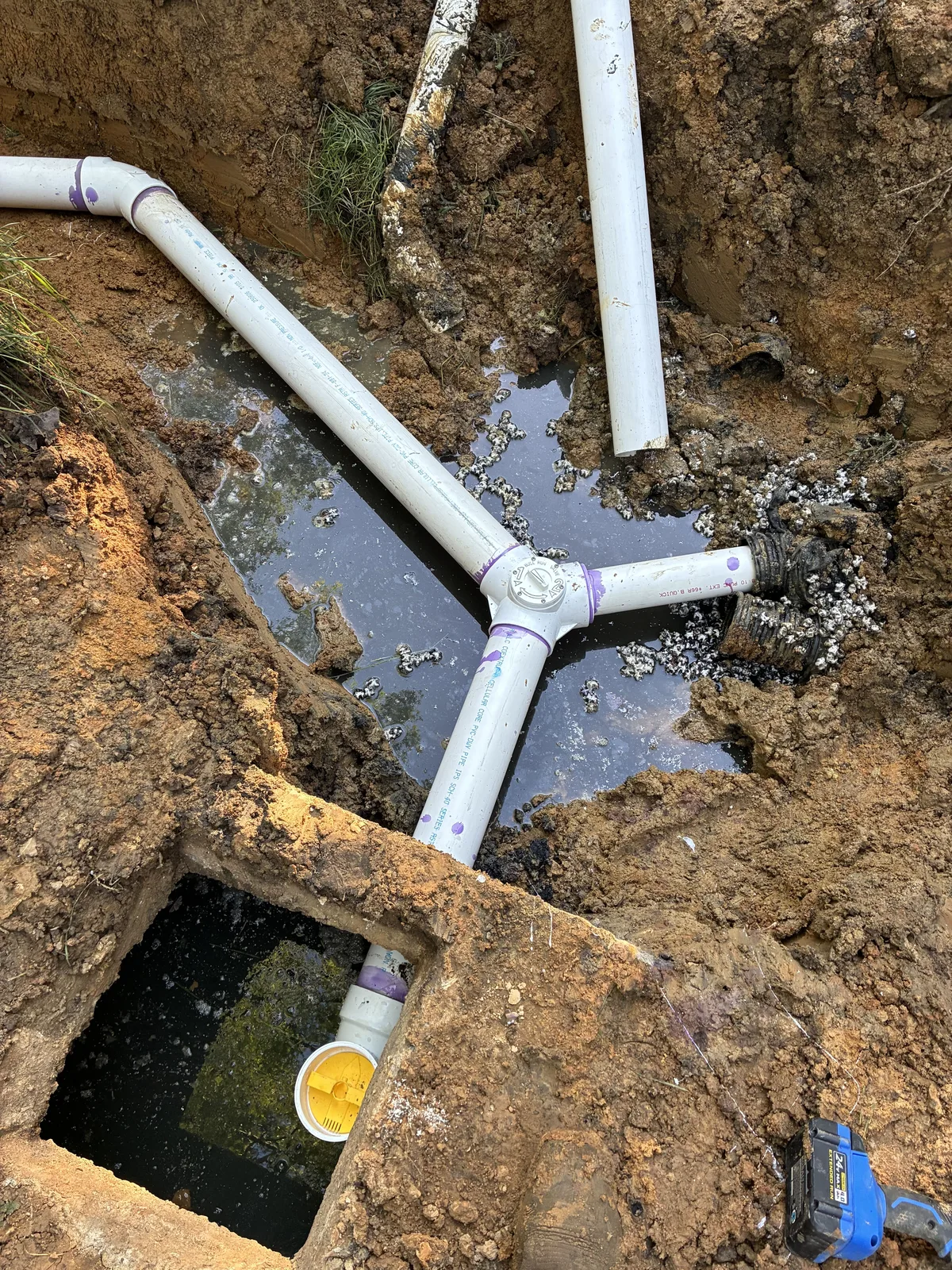 PVC sewer line elbows assembled over the open access hole of a septic tank